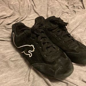 Women’s black leather Puma sneakers. With white outline Puma on outside of shoe